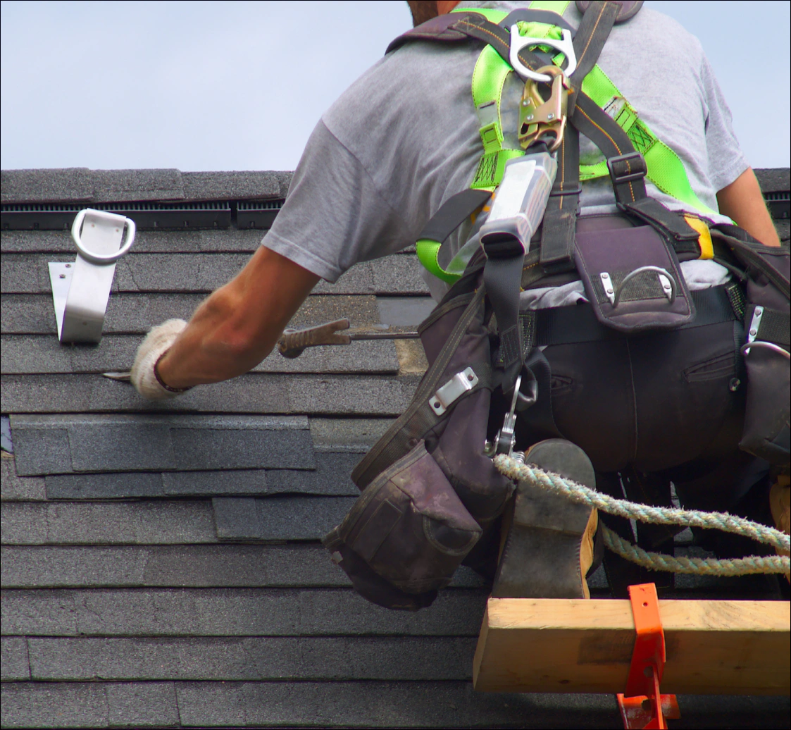 man installing asphalt roofing